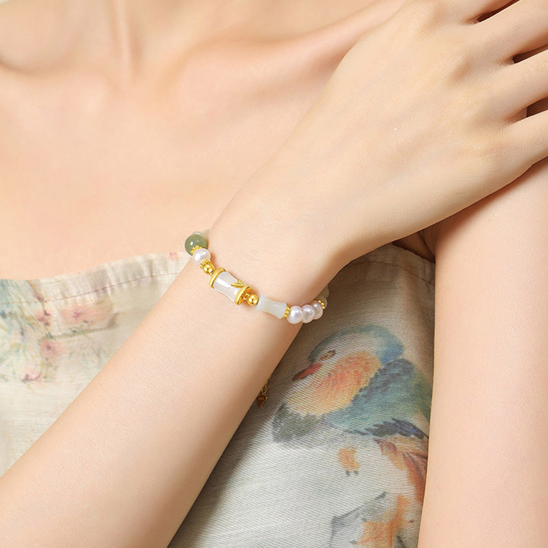 Armband mit weißer Jade und goldenen Perlen am Handgelenk getragen