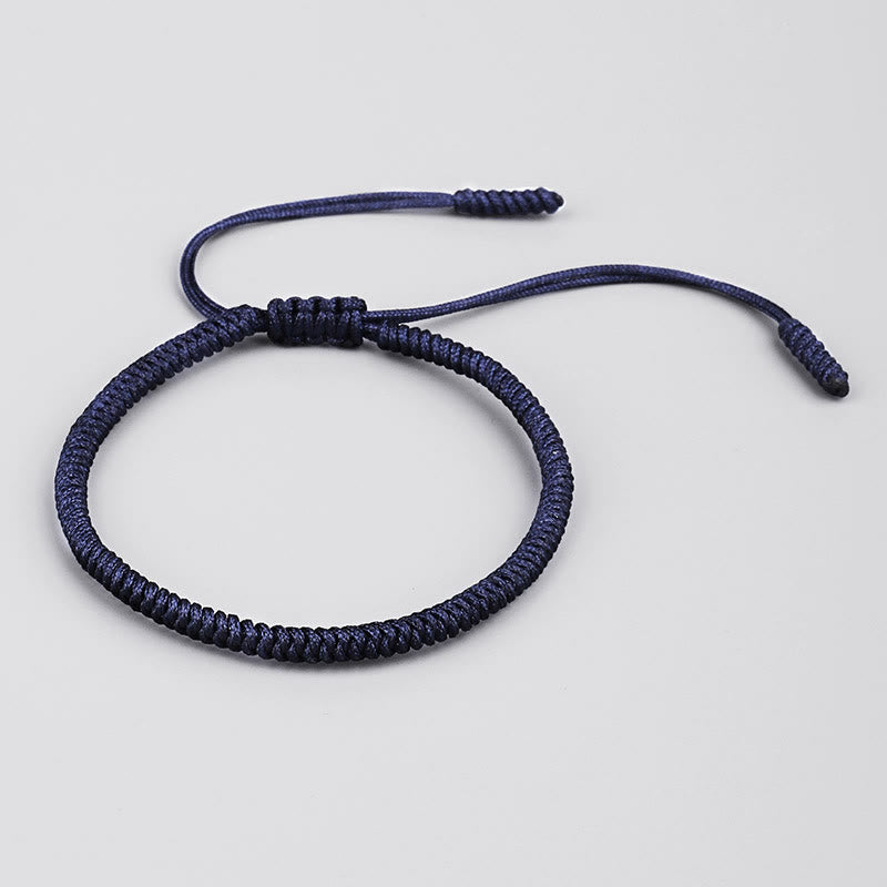 Dunkelblaues geflochtenes Armband mit Knoten auf neutralem Hintergrund