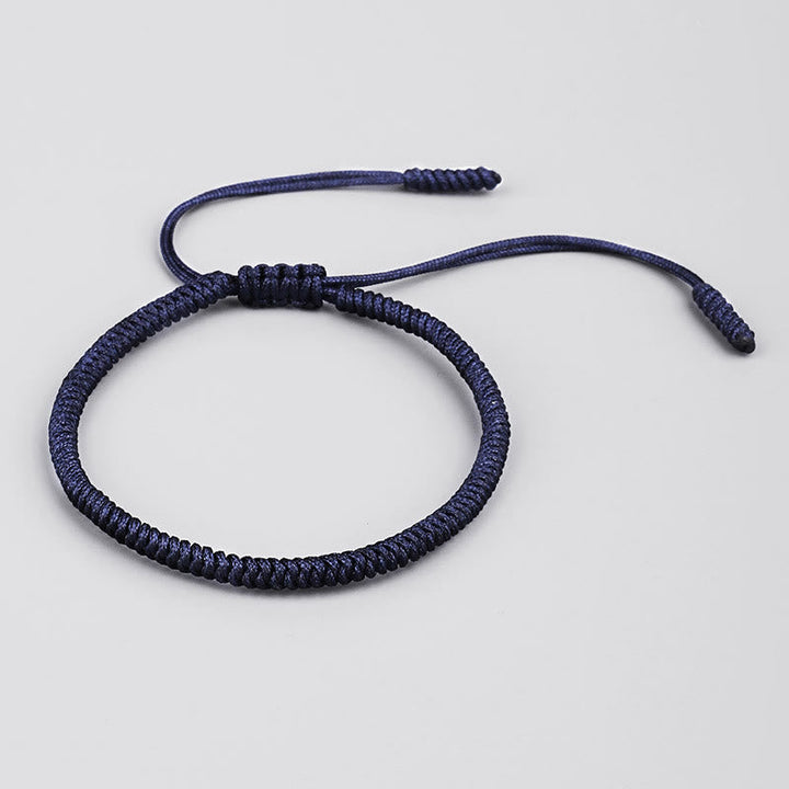 Dunkelblaues geflochtenes Armband mit Knoten auf neutralem Hintergrund