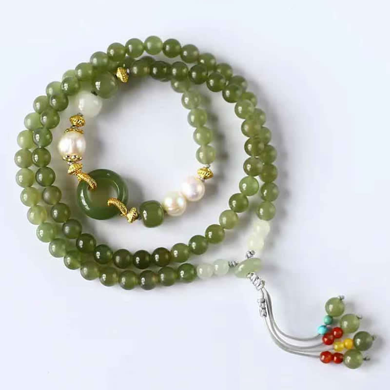 Grünes Jade Armband mit Perlen und goldenen Elementen auf weißem Hintergrund.