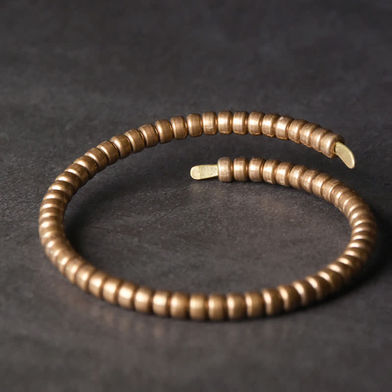 Armband Kupfer – Balance elastisch gewickelt auf grauem Hintergrund