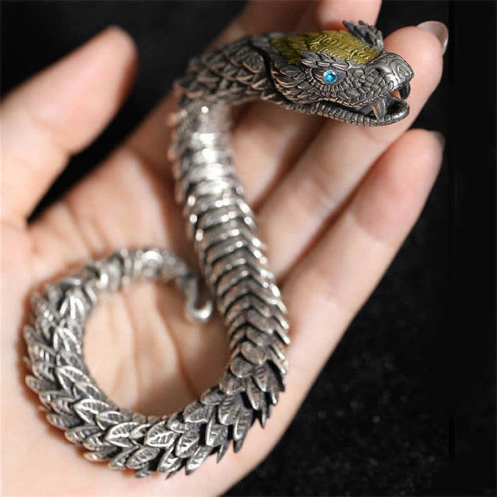 Silbernes Drachen Armband mit blauen Augen in Hand getragen.