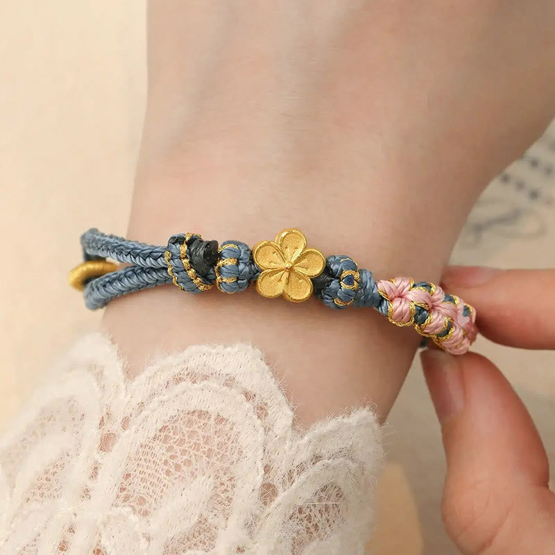 Armband Pfirsichblüte – Wohlstand mit goldener Blume am Handgelenk getragen