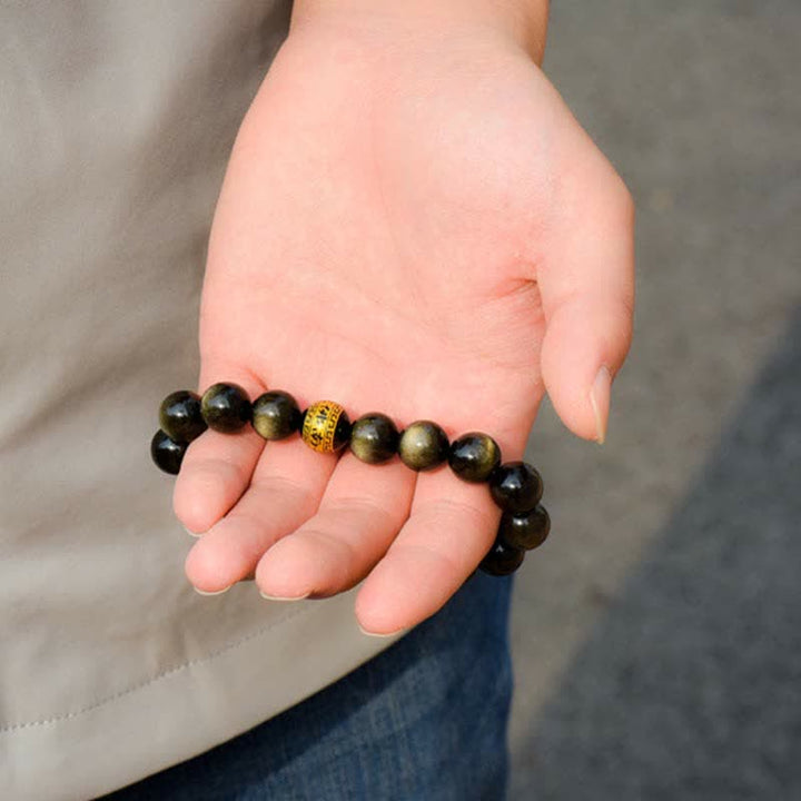 Obsidian Armband mit goldenem Element am Handgelenk getragen schwarze Perlen