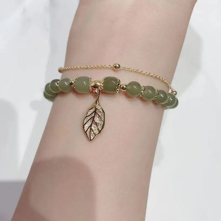 Jade-Armband mit Blattanhänger am Handgelenk, grüne Perlen Glück.