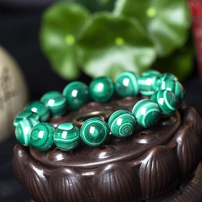 Mala Malachit Armband grüne Kugeln Naturstein auf braunem Holz Schale