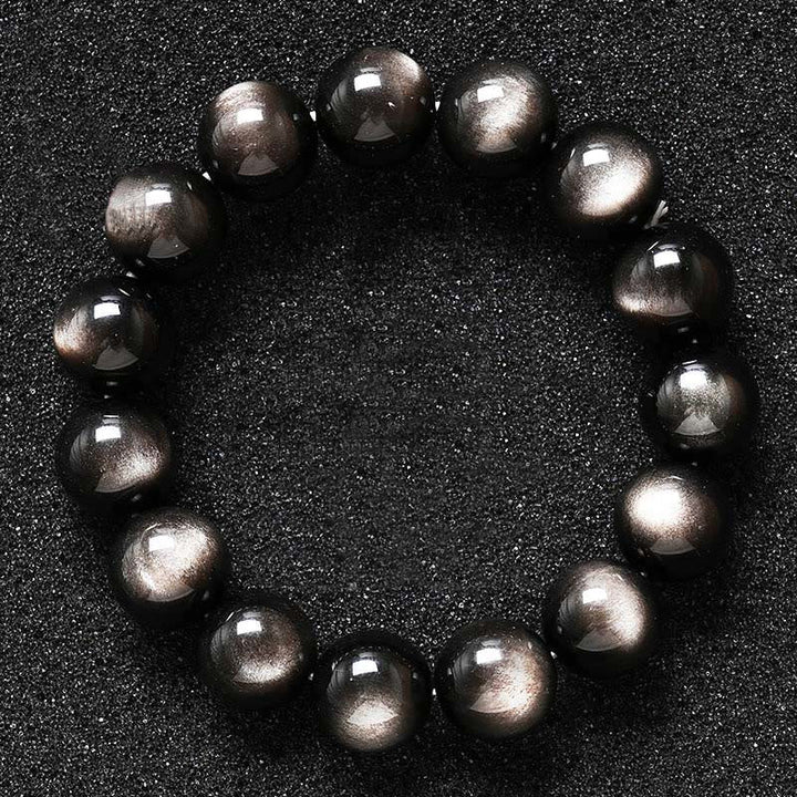 Armband Silber Obsidian – Schutz glänzende schwarze Kugeln auf dunklem Hintergrund
