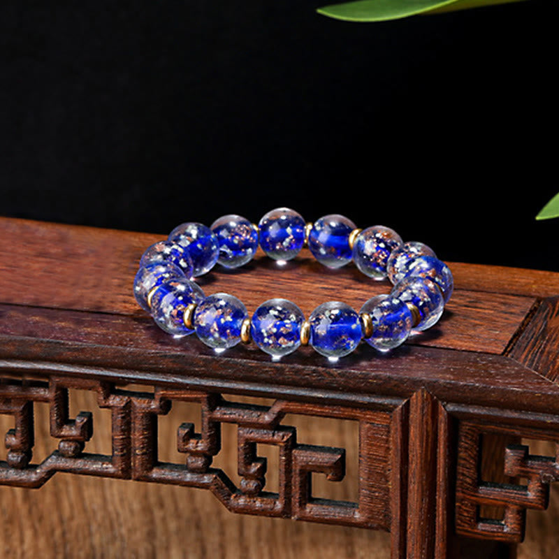 Blaues Kristall Armband mit Goldakzenten auf Holzoberfläche elegantes Design