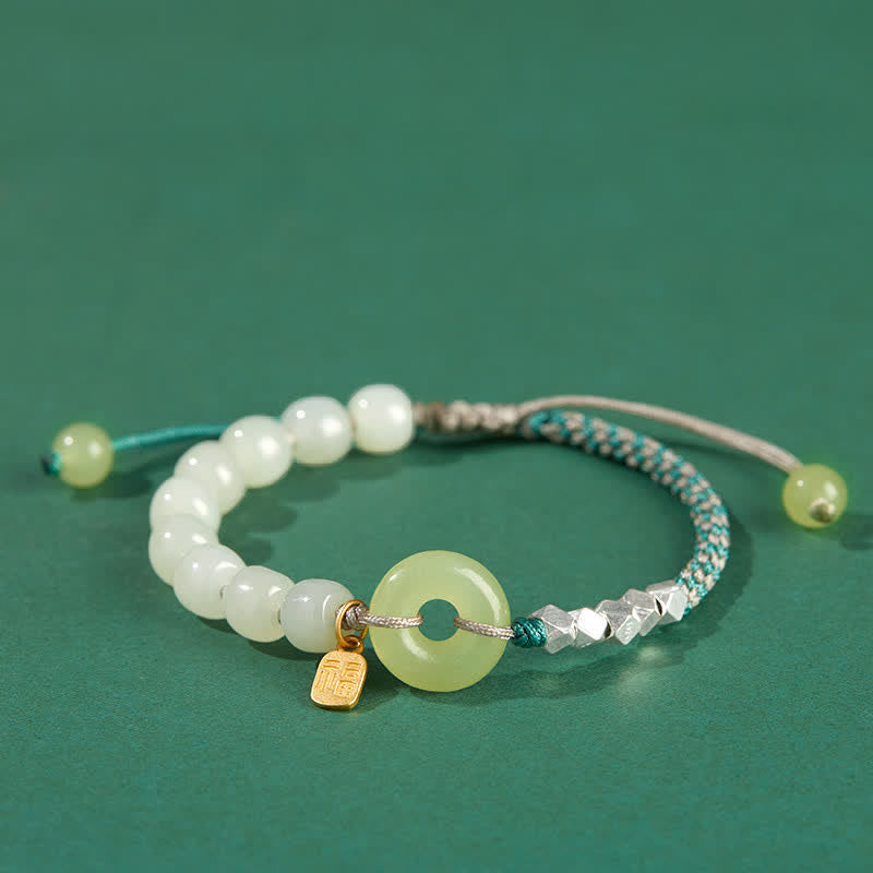 Jade Armband mit weißen Perlen und silbernen Elementen grüner Hintergrund
