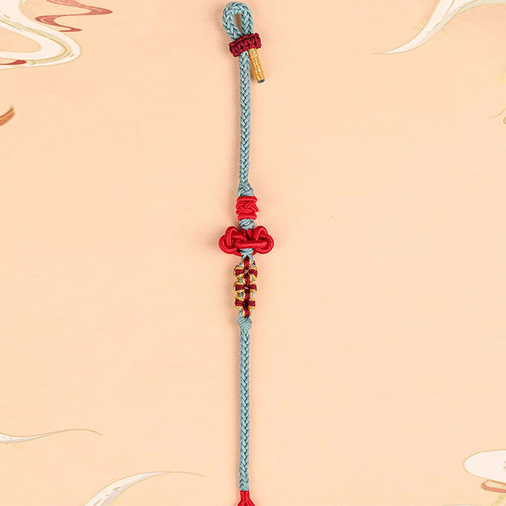 Hellblaues Armband mit roten Verzierungen und Quasten – Glück & Stärke & Balance