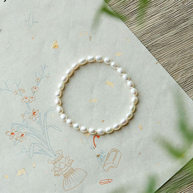 Armband Perle – Heilung elegantes Perlenarmband auf dekorativem Papier