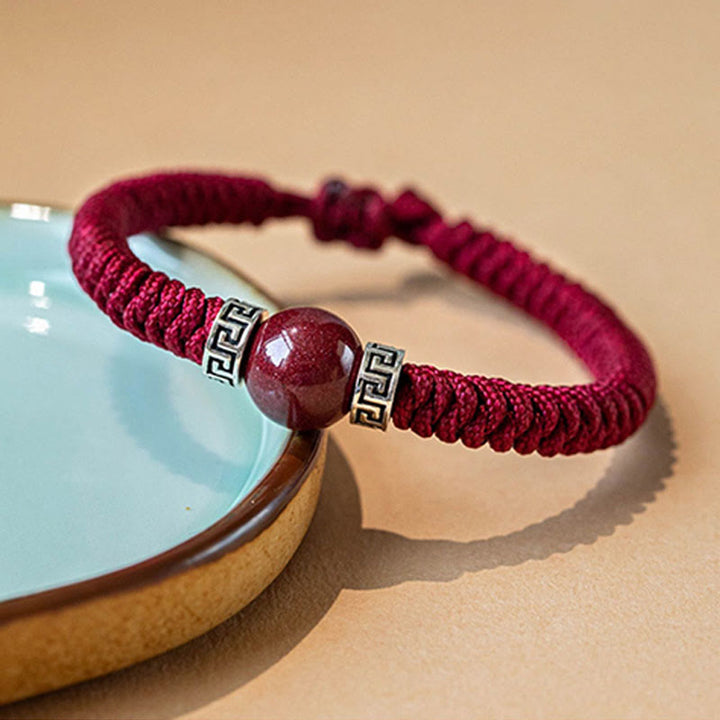 Burgunderrotes Armband mit Zinnober Stein und Silber Verzierungen elastisch.
