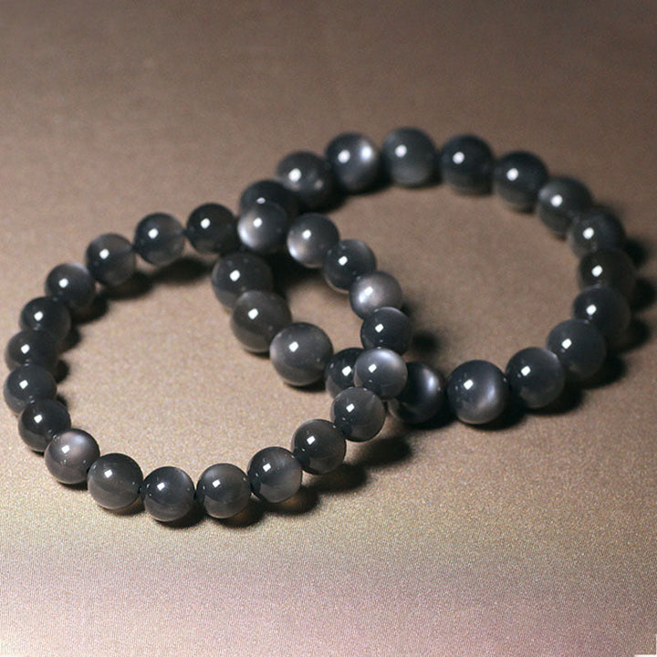 Mondstein Armband mit glänzenden schwarzen Perlen elastisch getragen