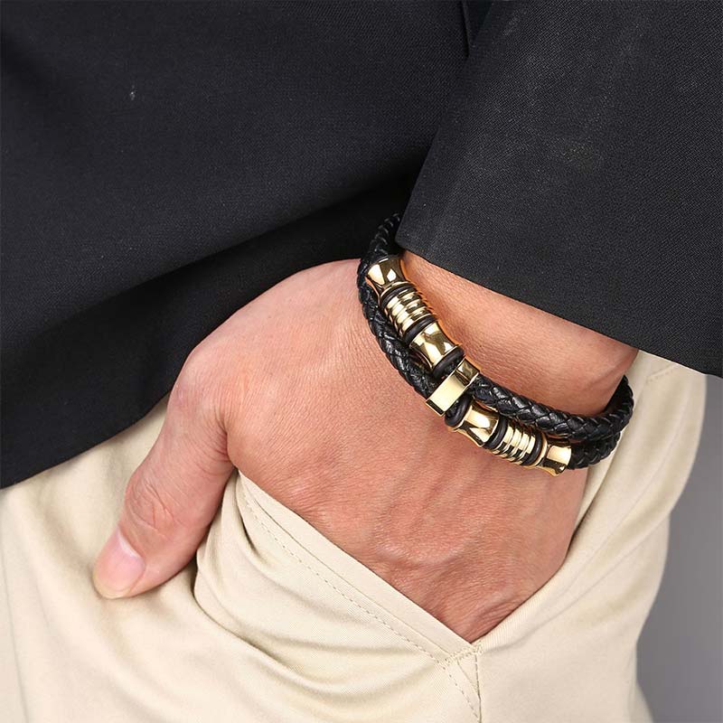 Schwarzes Leder Armband mit goldenen Elementen am Handgelenk getragen