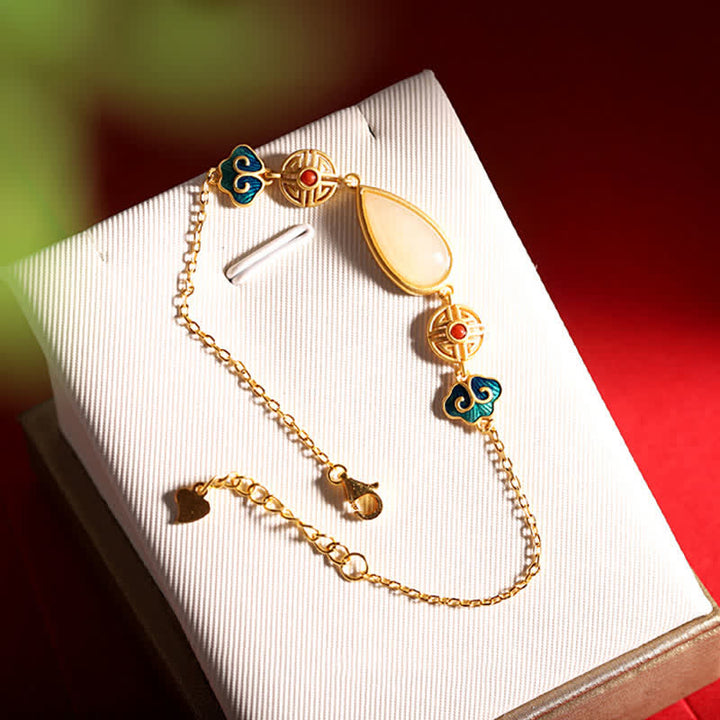 Goldenes Armband mit Jade Anhänger und dekorativen Perlen elegant.