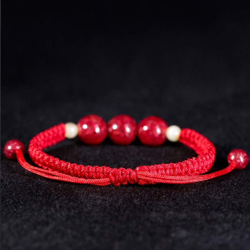 Rotes Armband Zinnober – Segen mit Perlen auf schwarzem Hintergrund Nahaufnahme