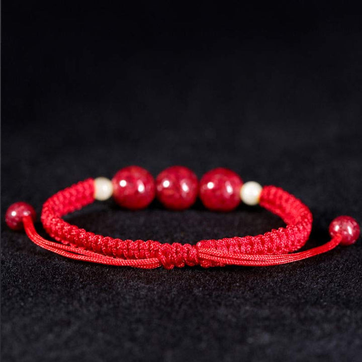 Rotes Armband Zinnober – Segen mit Perlen auf schwarzem Hintergrund Nahaufnahme
