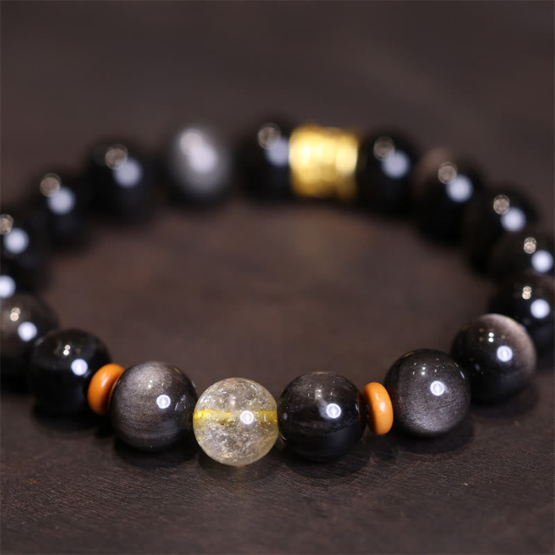 Schwarzes Obsidian Kristall Armband mit goldenen Perlen elastisch getragen.