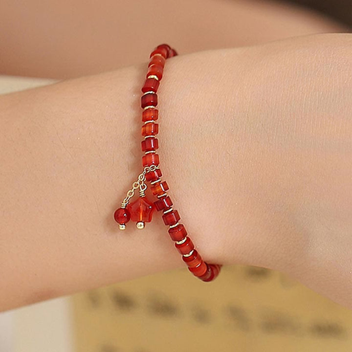 Rotes Achat Armband mit Kleeblatt Charm am Handgelenk getragen