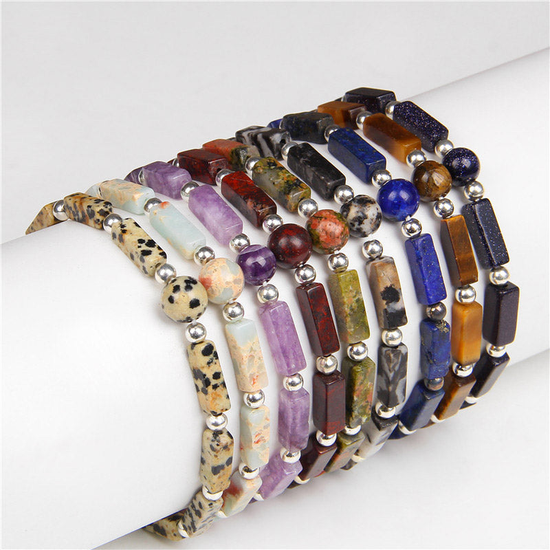 Mehrere bunte Armbänder Tigerauge Amethyst auf weißem Armmodell getragen