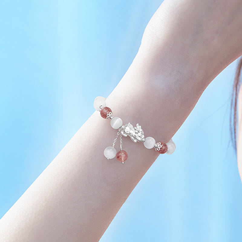 Armband Erdbeerquarz Mondstein Pixiu elegant am Handgelenk getragen