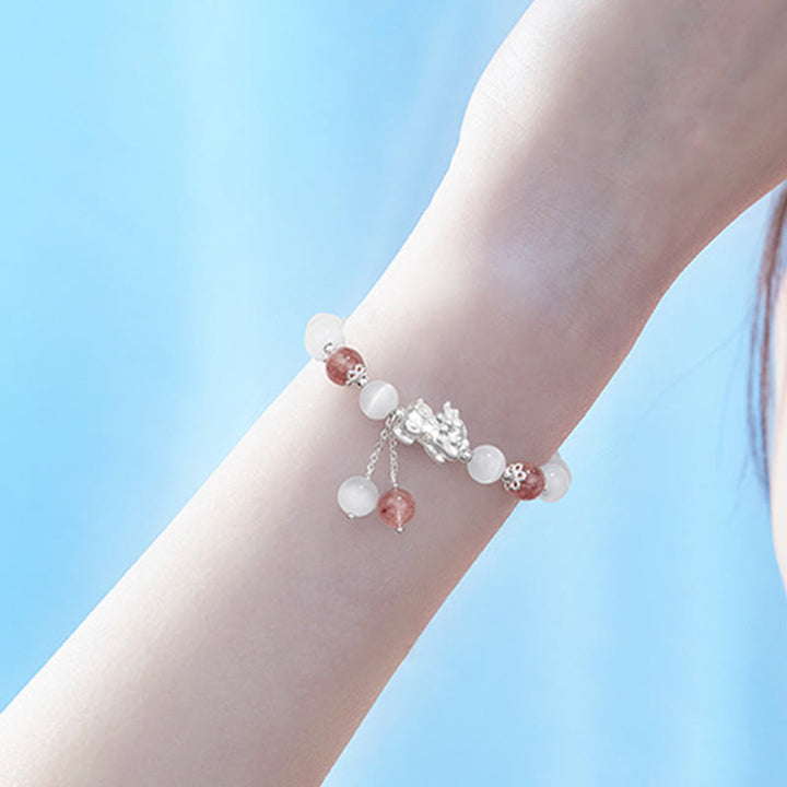 Armband Erdbeerquarz Mondstein Pixiu elegant am Handgelenk getragen