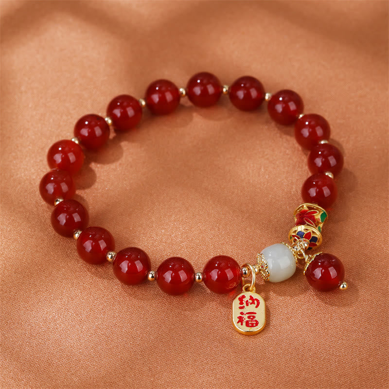 Armband Roter Achat Jade mit goldenem Segenanhänger am Handgelenk