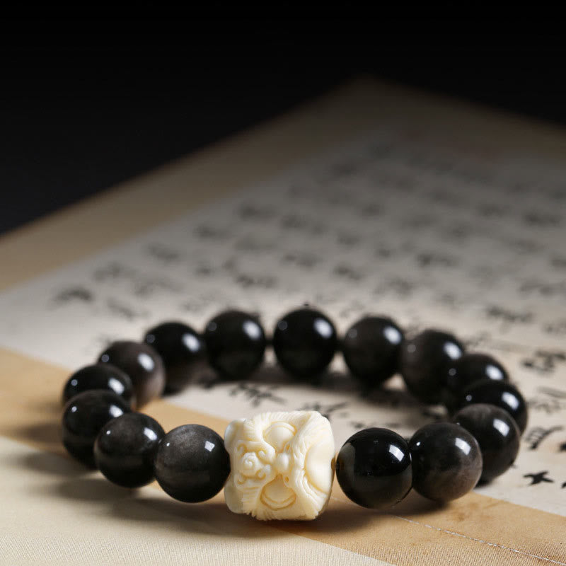 Schwarzes Obsidian Armband mit Bodhi-Anhänger auf Papier.