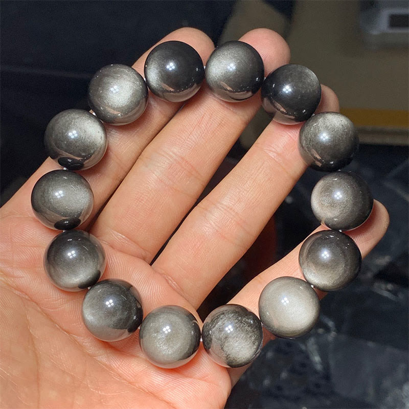 Silber Obsidian Armband am Handgelenk getragen, glänzende graue Natursteinkugeln elastisch