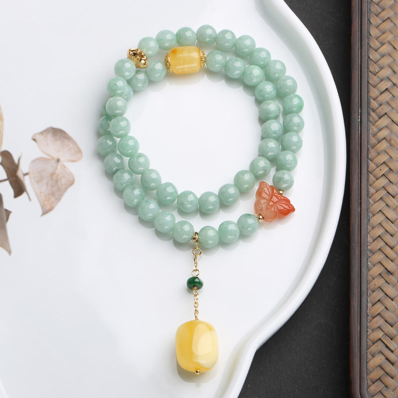 Jadegrünes Armband mit gelbem Stein und rotem Schmetterling Anhänger.