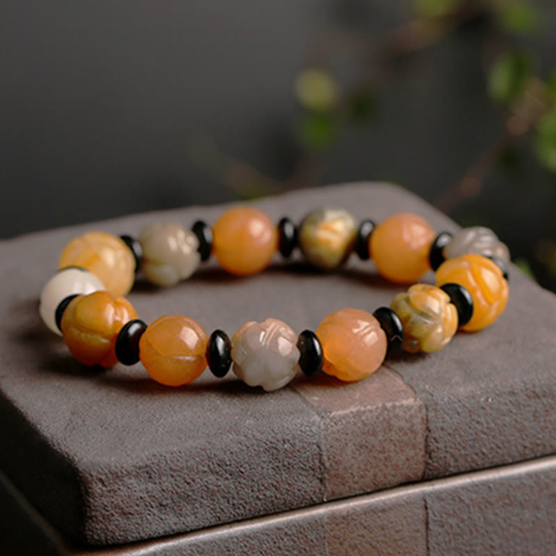 Jade Lotus Armband mit orangefarbenen und weißen Steinen elastisch getragen.