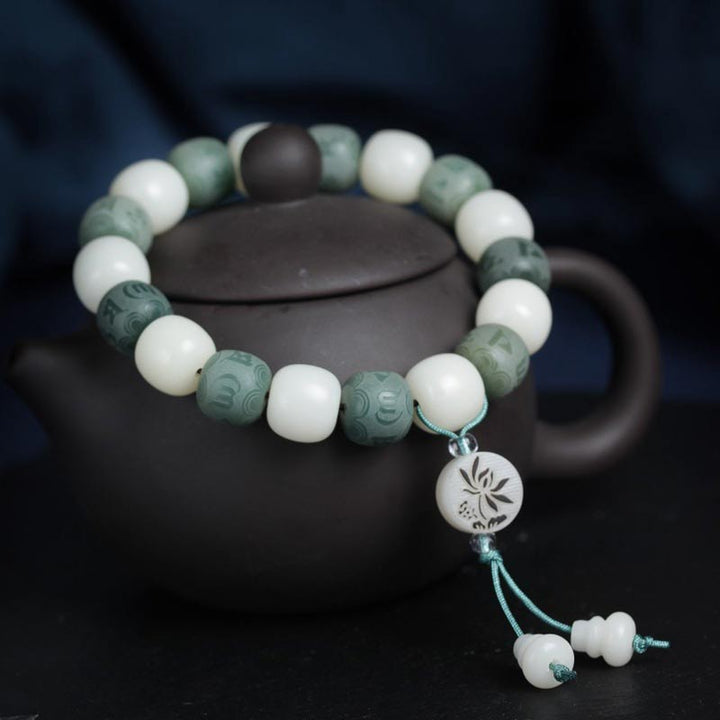 Armband Weiße Jade Bodhi Om Mani auf schwarzer Teekanne präsentiert