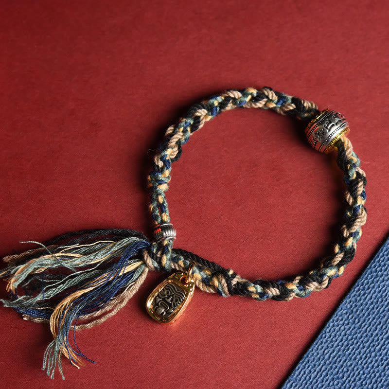 Geflochtenes Armband Om Mani Padme Hum mit Quasten und Metallplakette elegante Details