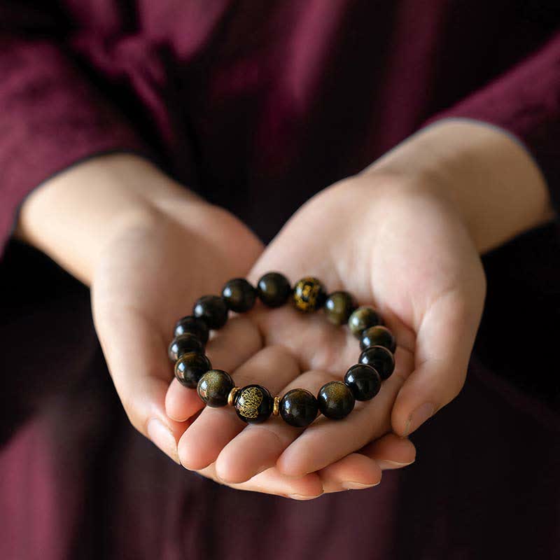 Obsidian Armband mit chinesischem Tierkreis in Hand gehalten Schutz
