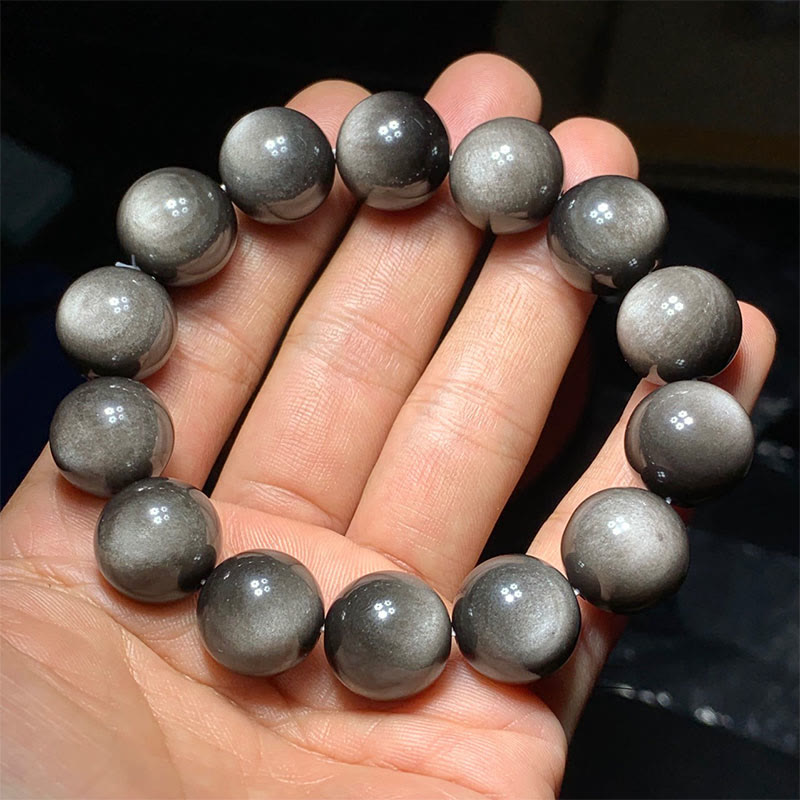 Silber Obsidian Armband am Handgelenk getragen, glänzende graue Natursteinkugeln elastisch