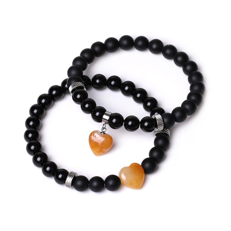 Armband Schwarzer Onyx Kristall Paar mit orangefarbenen Herzanhängern elastisch.