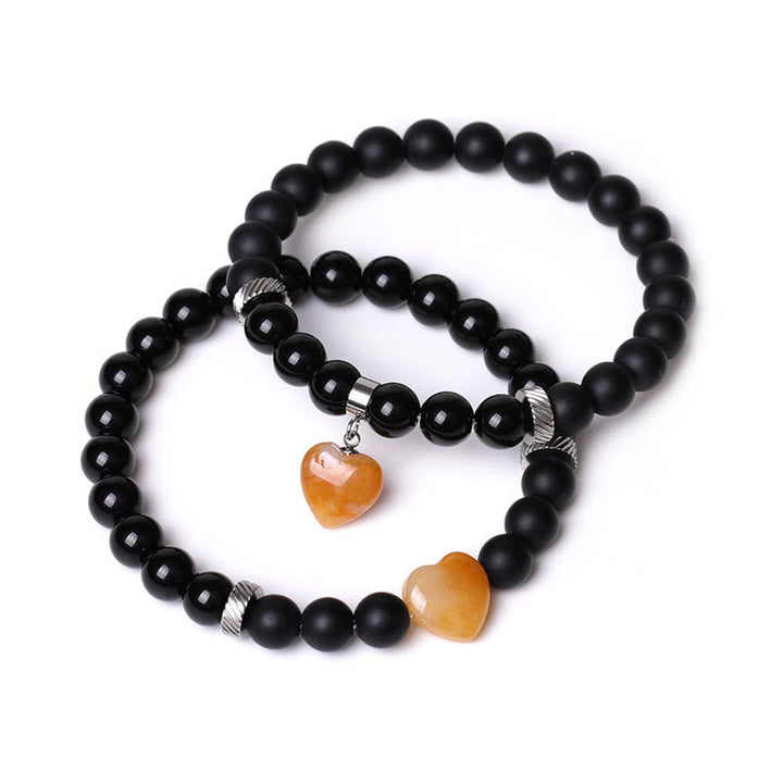 Armband Schwarzer Onyx Kristall Paar mit orangefarbenen Herzanhängern elastisch.
