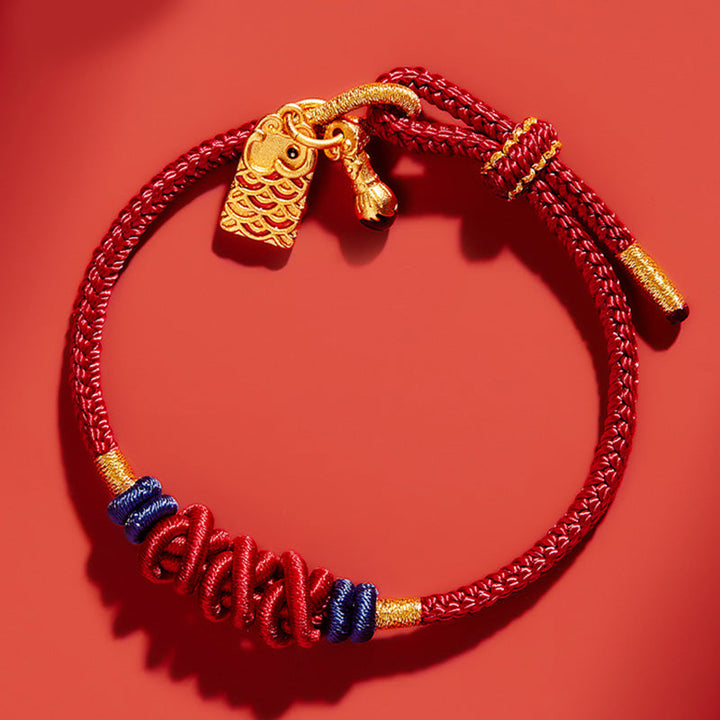 Rotes Seidenkordel-Armband mit goldenem Fisch-Anhänger elastisch getragen.