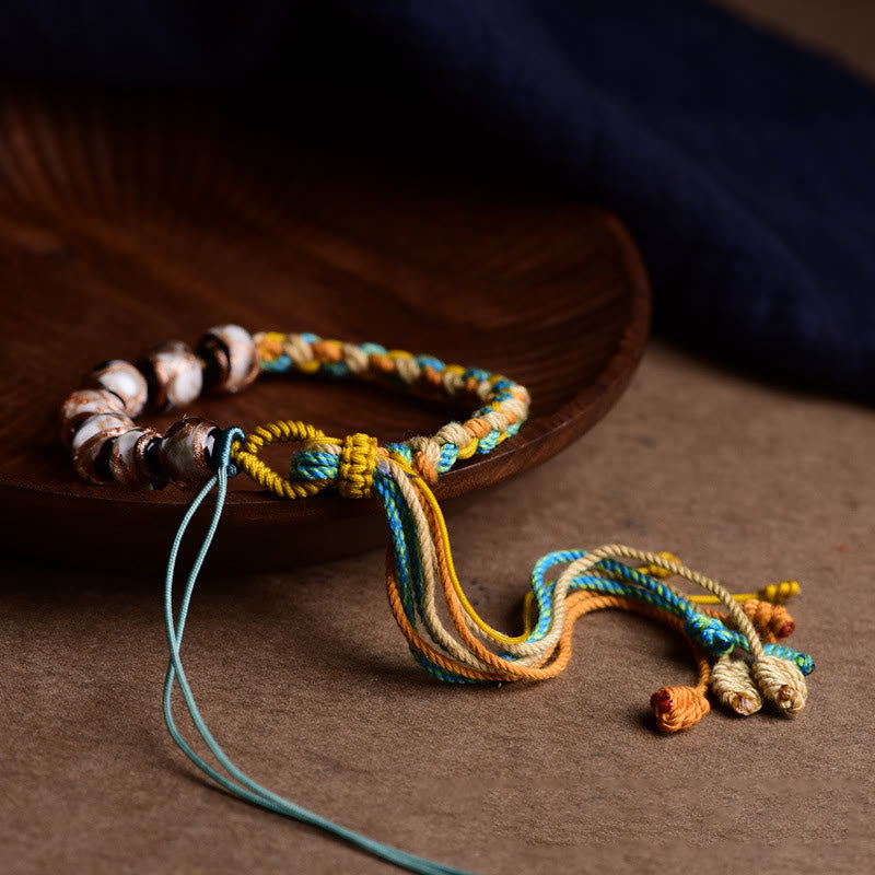 Buntes Armband mit Liuli Glas Perlen auf Holzschale elegant.