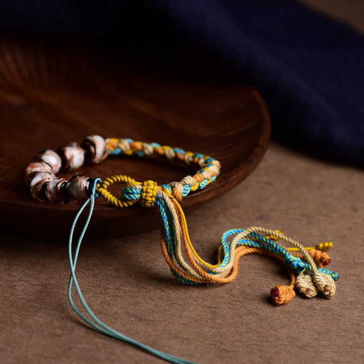 Buntes Armband mit Liuli Glas Perlen auf Holzschale elegant.