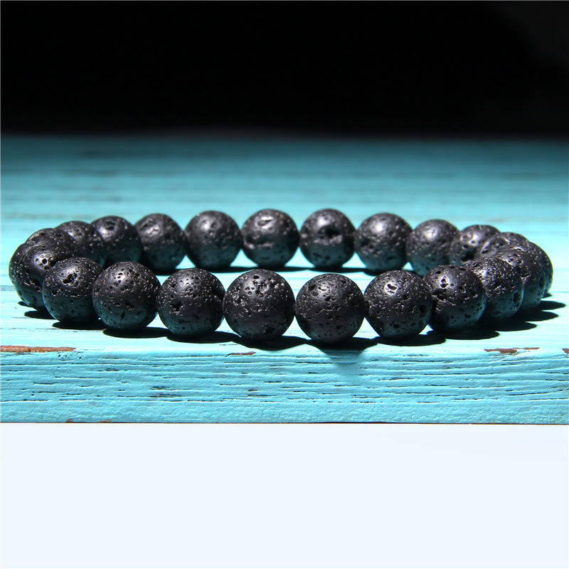 Schwarzes Achat Armband Kristall Perlen flach auf türkis Holz Balance