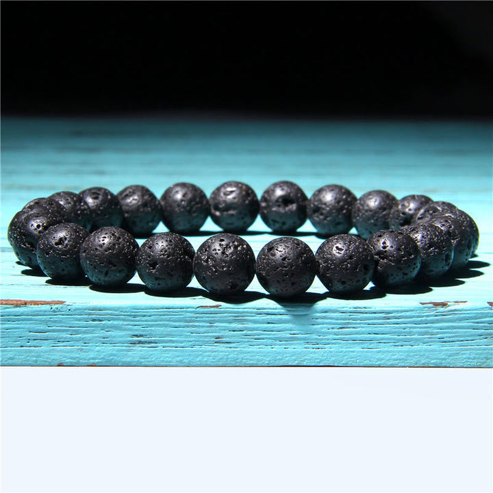 Schwarzes Achat Armband Kristall Perlen flach auf türkis Holz Balance