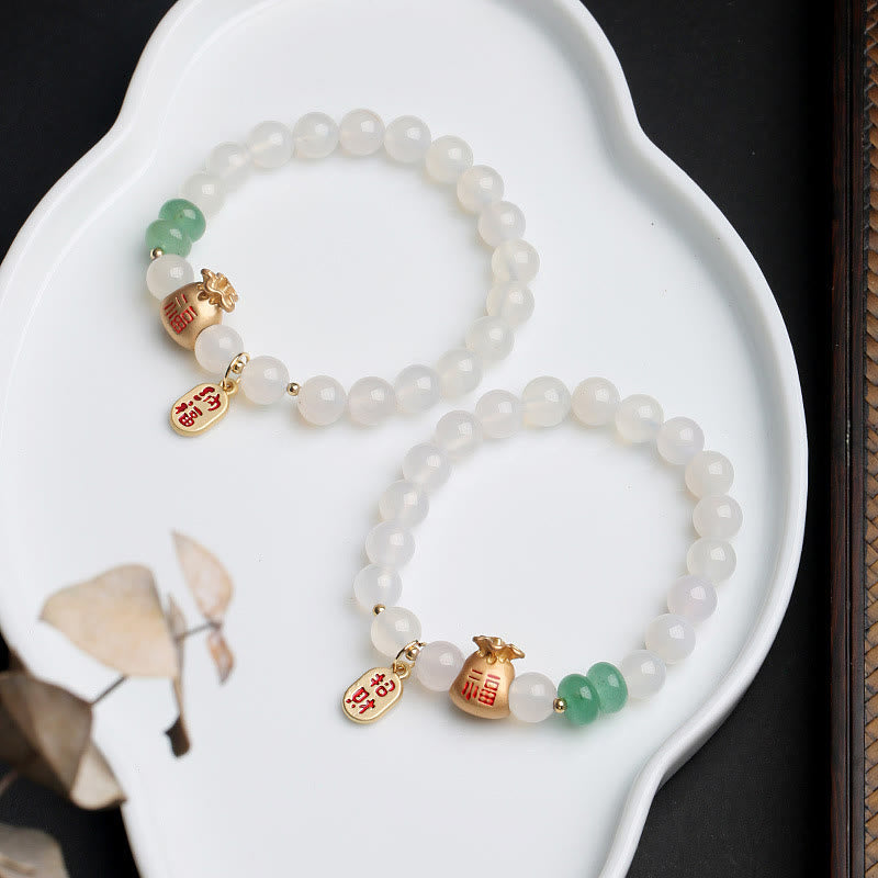 Weißes Perlenarmband mit grünem Jade und goldenem Fu-Zeichen Anhänger.