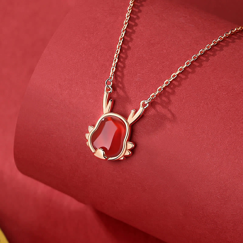 Elegantes Armband mit rotem Achat Anhänger auf rotem Hintergrund präsentiert.