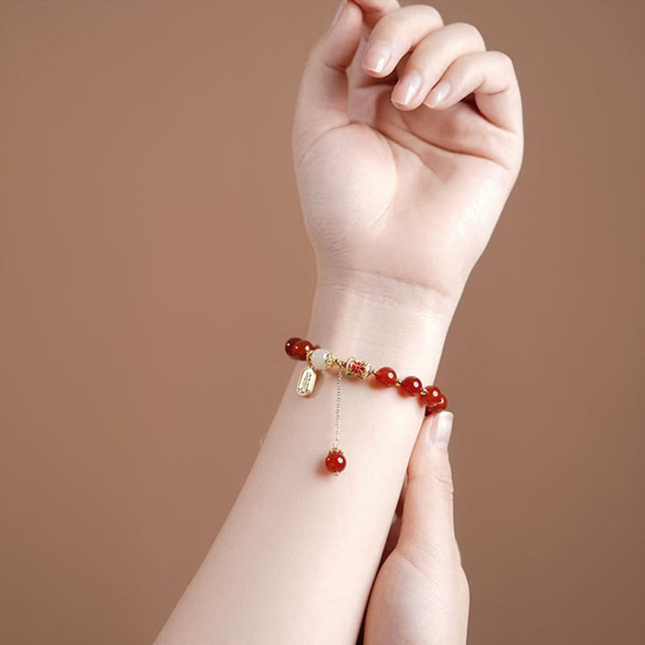 Armband Roter Achat mit Jade Fu-Zeichen Charm am Handgelenk getragen