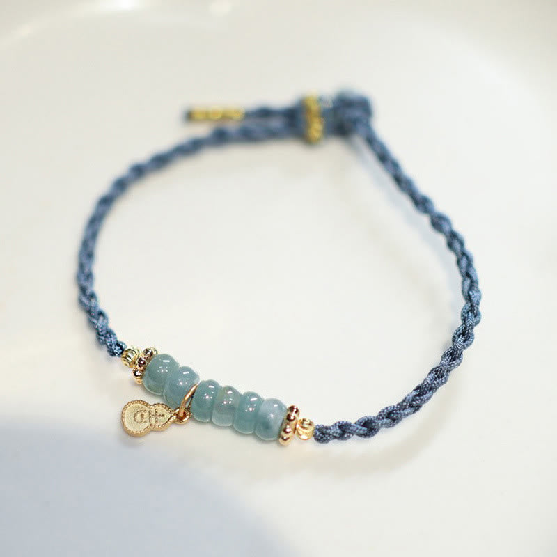 Blaues Armband mit Jade-Perlen und goldenem Glückszeichen Charm.