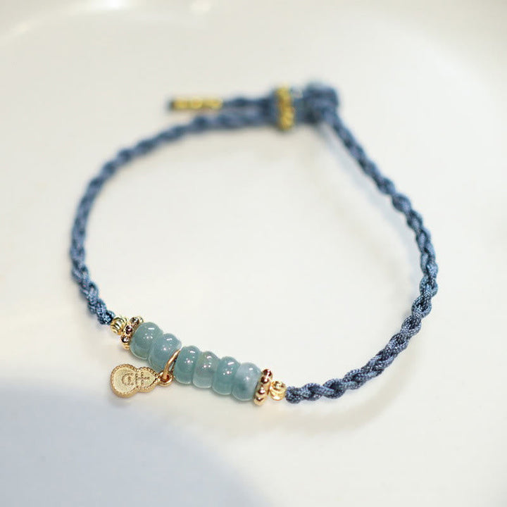 Blaues Armband mit Jade-Perlen und goldenem Glückszeichen Charm.