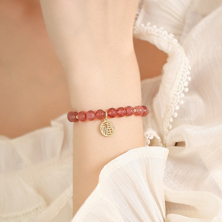 Armband Erdbeerquarz Fu-Zeichen – Heilung am Handgelenk getragen weiß.