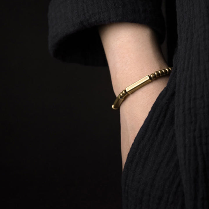Goldenes Armband am Handgelenk getragen elegantes Design schwarzer Stoff