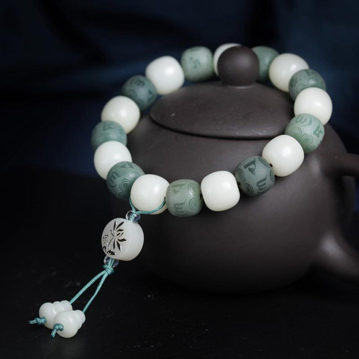 Armband Weiße Jade Bodhi Om Mani auf schwarzem Hintergrund displayiert.